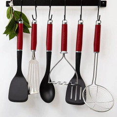 Conjunto de utensílios de cozinha com espátula perfurada vermelha e alça para pendurar, incluindo outros utensílios de manuseio.