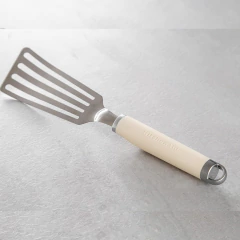 Espátula inox perfurada flexível de 33cm com cabo creme da KitchenAid.