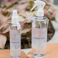 Frascos de água para tecidos da linha Luxury Day da Mels Brushes, com um frasco maior de 500 ml e um menor de 200 ml, sobre uma superfície clara.