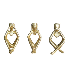 três estatuetas douradas decorativas para adornar a casa