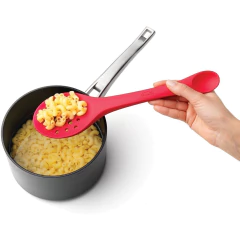 mulher utilizando colher vazada com furos para pegar o macarrão dentro de uma panela com água