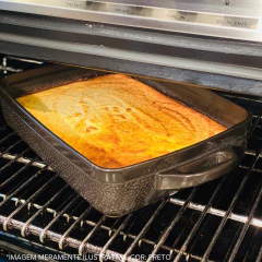 assadeira de cerâmica com alças no forno assando uma massa