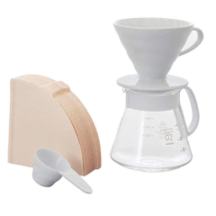 Kit V60 Hario em cerâmica branca com jarra de vidro e filtros para café.