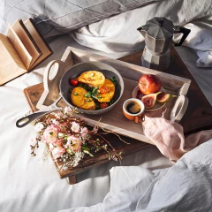 Frigideira antiaderente Salina Granitium de 20cm com omelete, tomates e arranjo de flores em uma bandeja sobre a cama.