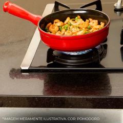 frigideira de cerâmica vermelha servindo uma refeição em cima de um fogão à gás