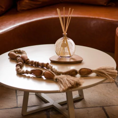 Difusor Jardim Sensorial em gel com varetas e glitter dourado em cima de uma mesa de centro