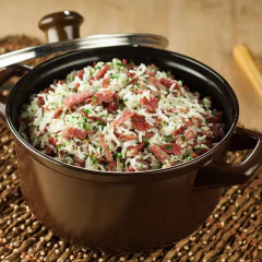 Panela de cerâmica Ceraflame Duo de 18cm com arroz e carne desfiada, decorada com ervas.