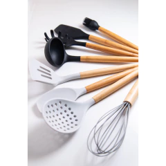utensílios de silicone preto com o cabo de madeira em cima de uma bancada