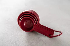 Conjunto de quatro xícaras medidoras vermelhas da KitchenAid empilhadas.