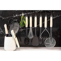 Conjunto de utensílios de cozinha pendurados em um suporte, incluindo colheres, espátulas e um batedor, em um fundo de mármore preto.