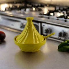 Mini tagine amarelo de cerâmica Ceraflame Gourmet em uma superfície de cozinha com fundo de fogão.