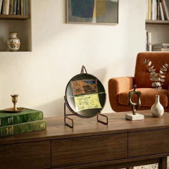 Prato de cerâmica redondo assinado por Megumi Yuasa em 1991, com design abstrato em tons de preto, marrom, azul e amarelo, medindo 25 cm