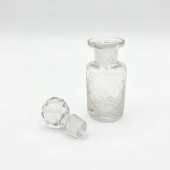 Frasco de perfume vintage em cristal transparente com tampa facetada e corpo com padrão quadriculado