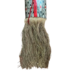 Máscara indígena Mehinaku com pintura geométrica preta, branca e vermelha, e franjas naturais na parte inferior