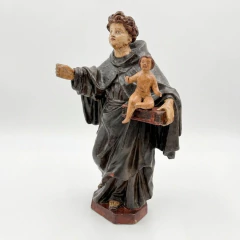 Escultura em terracota do século XVIII representando Santo Antônio com Menino Jesus, vestindo hábito preto e segurando a figura do Menino Jesus