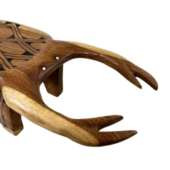 Banco indígena de madeira representando caranguejo com entalhes e pinturas tradicionais do povo Mehinaku