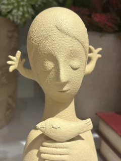 Escultura mulher com passarinho P na internet