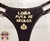 REF 116. Tanga Sexy lateral dupla com regulagem lateral cor preta estampas: Frente, LOIRA PUTA DE NEGROS, atrás, AMO ROLA PRETA. EM DOURADO.