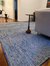 Tapete artesanal Tear em chenile azul marinho, algodão cru e sisal natural.