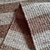 Tapete artesanal Tear em sisal polar e caramelo.