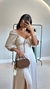 Mulher vestindo o Vestido Olive com manga bufante e fenda, segurando uma bolsa marrom.