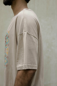 Remerón de color beige con diseño colorido en el lado izquierdo, visto de perfil.