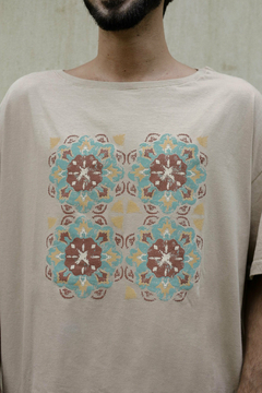 Remerón color beige con estampado de motivos geométricos en tonos azules y marrones.