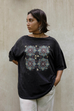 Remerón negro con estampado colorido en el frente, modelo de pie con fondo neutro.