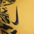 Detalhe do logo da Nike em uma camisa dourada do Inter de Milão III 2024/25 para torcedores masculinos.