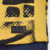 Detalhe da etiqueta da camisa dourada do Inter de Milão III 2024/25, com estampa e informações de engenharia.