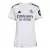 Camisa feminina do Real Madrid I 2025/26, cor branca, com detalhes em preto e amarelo.