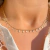 Colar choker com detalhes em gotas, banho de ouro 18k, ajustado ao pescoço.