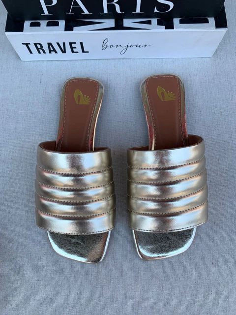 Rasteira slide feminina dourada com tiras acolchoadas e bico quadrado vista de cima.