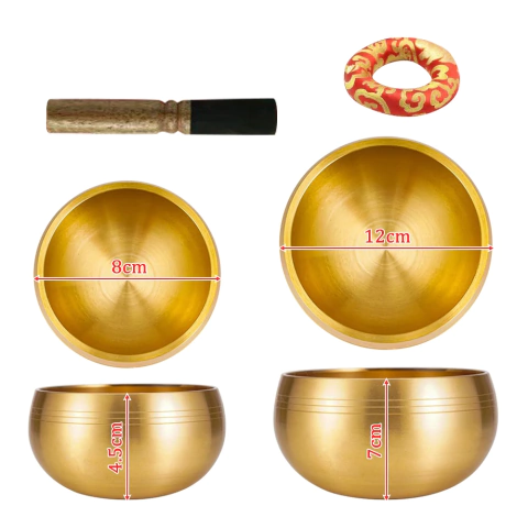 Par de tigelas tibetanas cantantes douradas com diâmetros de 12 cm e 8 cm, acompanhado de um bastão para tocar e uma almofada redonda decorativa vermelha e dourada