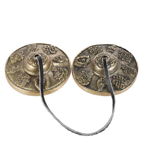 Címbalo tibetano tingsha de bronze com oito símbolos auspiciosos, conectado por uma corda.