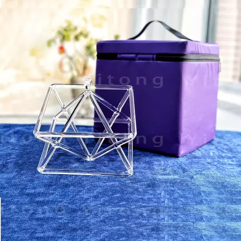Pirâmide de Cristal Merkaba de 8 polegadas sobre uma mesa azul, ao lado de uma caixa roxa.