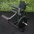 Banco combinado para gimnasio, equipo de musculación multifunción con respaldo acolchonado y soporte para pesas, ideal para ejercicios de piernas y fuerza, sobre fondo de pared verde.