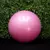 Pelota de esferodinamia rosa de 55 cm frente a fondo de hojas verdes