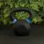 Pesa rusa de fundición de 12 kg con detalles azules, ideal para entrenamiento de fuerza.