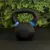 Pesa rusa de fundición de 12 kg sobre superficie negra, ideal para entrenamiento de fitness y musculación