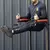 Hombre utilizando una estación rack multifunción para ejercicios de abdominales en un gimnasio, apoyado en los brazos y elevando las piernas.
