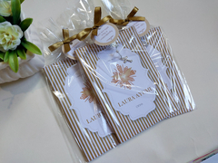 Conjunto de livros de orações com capa flexível, decorados com laços dourados e tags, apresentados em embalagem plástica.