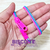 Foto: Pulseira zíper de plástico com uma faixa rosa e outra azul celeste.