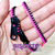 Foto: Pulseira zíper de plástico com uma faixa rosa e outra preta.