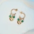 BRINCO ARGOLA SERENA COM PEDRAS VERDE BANHADO A OURO