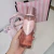 Frasco de body splash Victoria’s Secret Darling Vanilla Jasmine 250ml na mão feminina, com bolsa e sacola rosa ao fundo