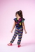 Menina usando conjunto infantil preto com flores coloridas e calças xadrez multicoloridas.