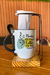 Caneca personalizada com a frase "Plantei uma amiga, colhi uma irmã", acompanhada de colher e suporte.