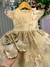 Vestido infantil dourado com detalhes em renda e flores, acompanhado de sapatinhos dourados