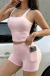 Mulher usando conjunto de shorts e top rosa claro da Flip Moda Gringa, com celular no bolso lateral do short.
